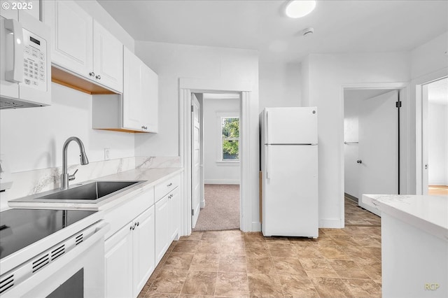 kitchen featuring white appliances, a sink, white cabinets, and light countertops