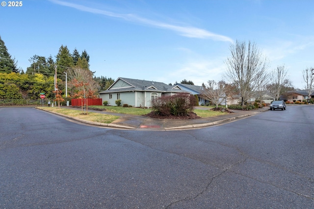 view of road with curbs, traffic signs, sidewalks, and a residential view