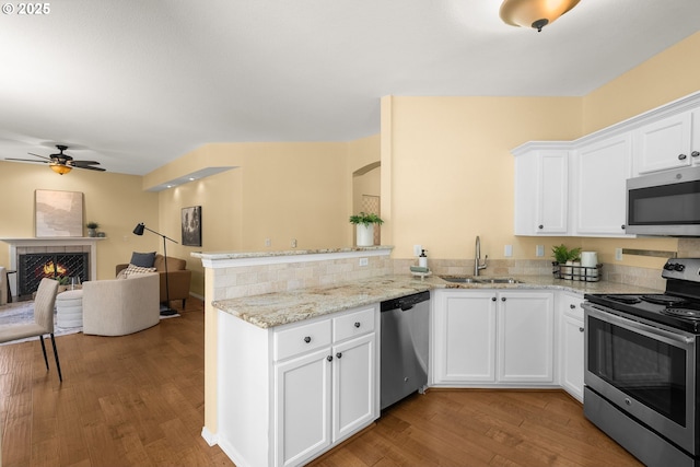 1231 NE Horizon Loop Unit 203, Hillsboro, OR 97124 - kitchen with appliances with stainless steel finishes, a sink, open floor plan, wood finished floors, and a peninsula