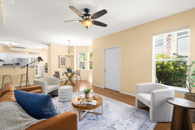 1231 NE Horizon Loop Unit 203, Hillsboro, OR 97124 - living room featuring a wall mounted air conditioner, a ceiling fan, a chandelier, and wood finished floors