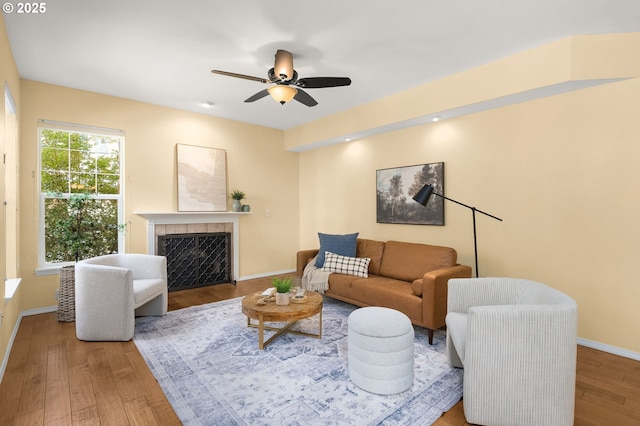 1231 NE Horizon Loop Unit 203, Hillsboro, OR 97124 - living room featuring wood finished floors, baseboards, a tiled fireplace, and a ceiling fan
