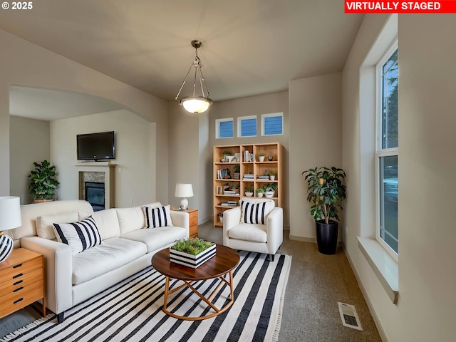 carpeted living room with a premium fireplace