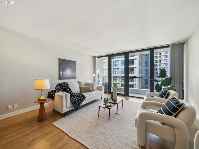 255 SW Harrison St Unit 9C, Portland, OR 97201 - living room with wood finished floors, baseboards, and floor to ceiling windows
