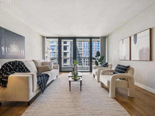 255 SW Harrison St Unit 9C, Portland, OR 97201 - living room with wood finished floors, baseboards, and a wall of windows