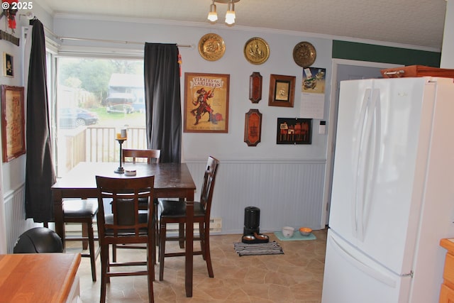 dining space with ornamental molding and a textured ceiling