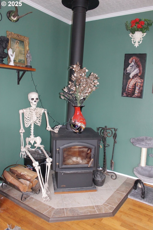 interior details featuring wood-type flooring, ornamental molding, and a wood stove