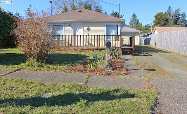 view of front of home with a wooden deck and a front lawn