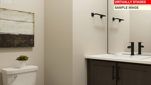 half bathroom featuring vanity and toilet