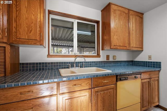 kitchen featuring white dishwasher, sink, and tile countertops