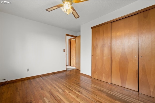 unfurnished bedroom with ceiling fan, light wood-type flooring, and a closet