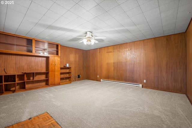 interior space with baseboard heating, ceiling fan, built in shelves, and wood walls