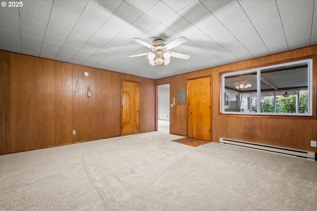 spare room with ceiling fan, light colored carpet, wooden walls, and a baseboard heating unit