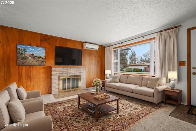 living room featuring a fireplace, wooden walls, an AC wall unit, and a textured ceiling