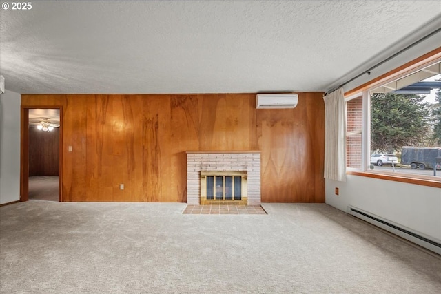 unfurnished living room featuring baseboard heating, wooden walls, a fireplace, and a wall unit AC