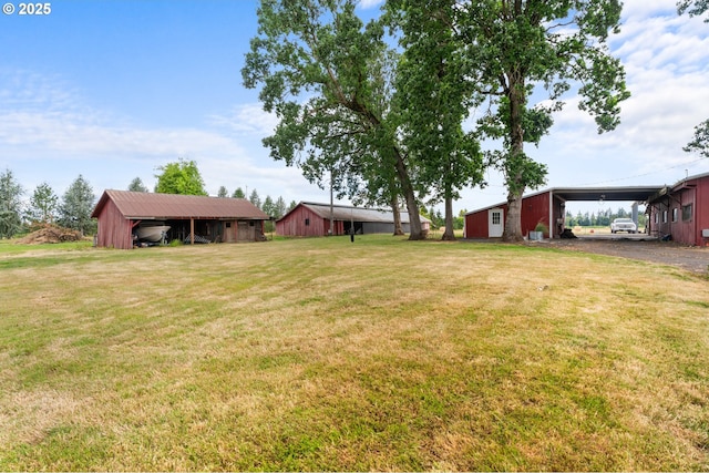 8747 S Heinz Rd, Canby, OR 97013 - view of green lawn featuring an outbuilding, a carport, driveway, and an outdoor structure
