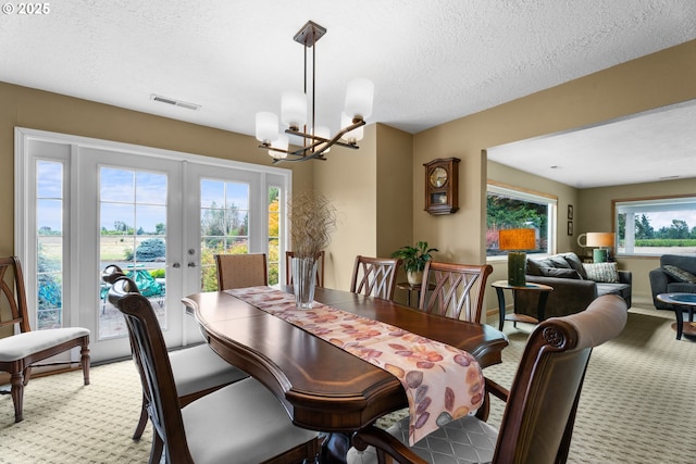 8747 S Heinz Rd, Canby, OR 97013 - dining room featuring light colored carpet, a chandelier, french doors, and a textured ceiling