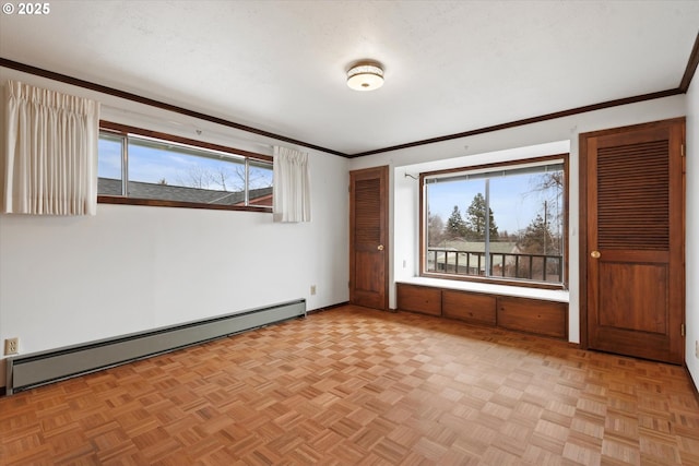 empty room with a baseboard heating unit, plenty of natural light, and light parquet flooring