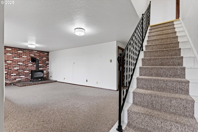 interior space with carpet, a textured ceiling, and a wood stove