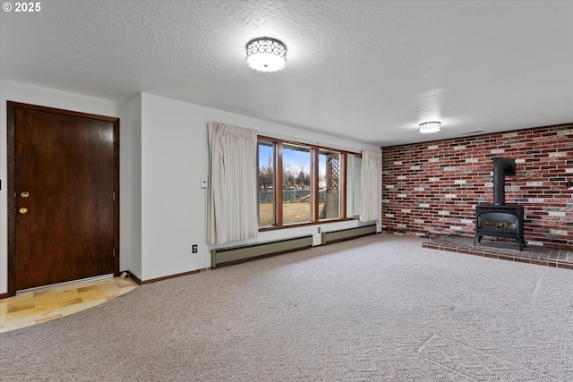 unfurnished living room featuring a wood stove, light carpet, a textured ceiling, and baseboard heating