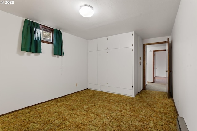 unfurnished bedroom with light carpet, a baseboard radiator, and a closet