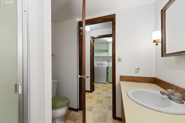 bathroom with vanity, washer / dryer, and toilet