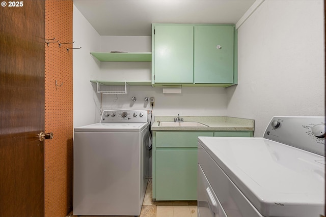 washroom with independent washer and dryer, cabinets, and sink