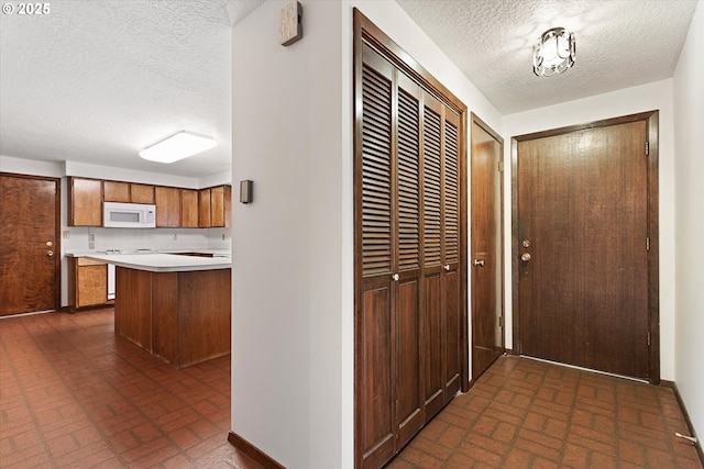 doorway to outside featuring a textured ceiling