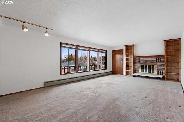 unfurnished living room featuring a baseboard radiator, a brick fireplace, carpet floors, and a textured ceiling