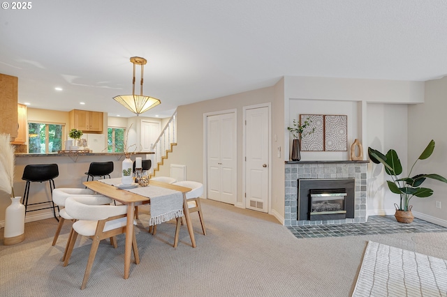 2805 NW Upshur St Unit B, Portland, OR 97210 - dining room featuring stairs, a brick fireplace, light colored carpet, and recessed lighting