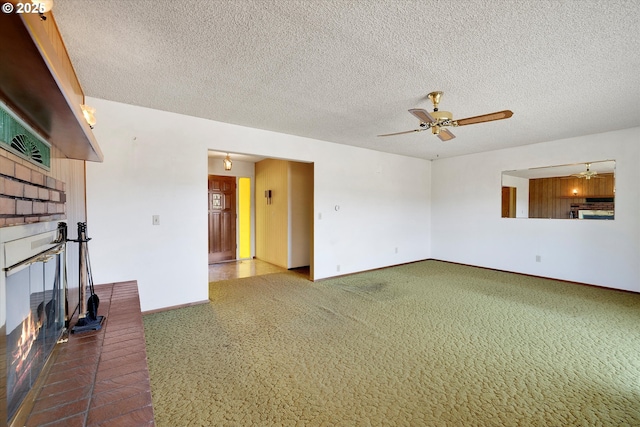 unfurnished living room featuring carpet floors, a textured ceiling, a fireplace, and ceiling fan
