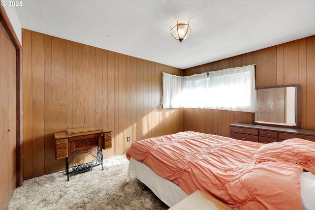 carpeted bedroom with wooden walls and a closet