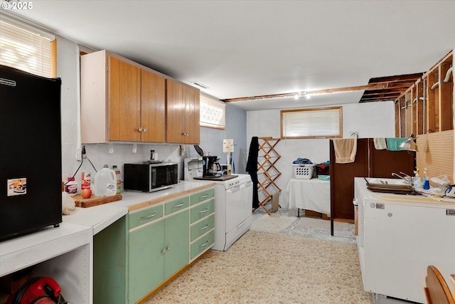 kitchen featuring sink, washer / dryer, white fridge, and green cabinets