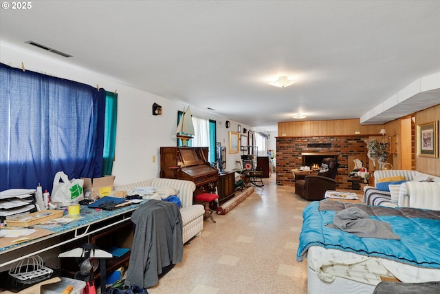 living room with a brick fireplace and wood walls