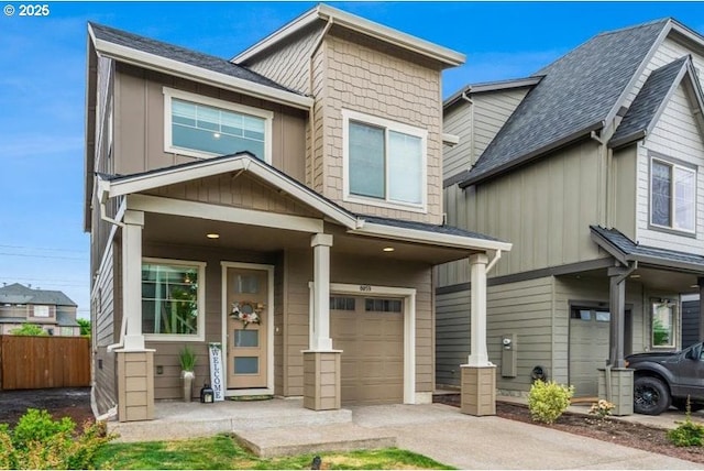 view of front of property featuring an attached garage, fence, board and batten siding, and concrete driveway