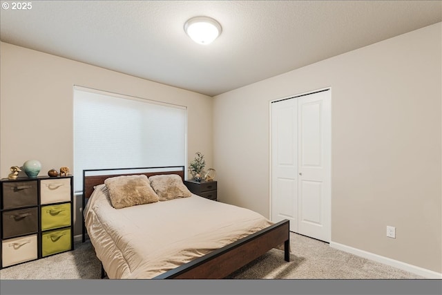 carpeted bedroom featuring a closet and baseboards