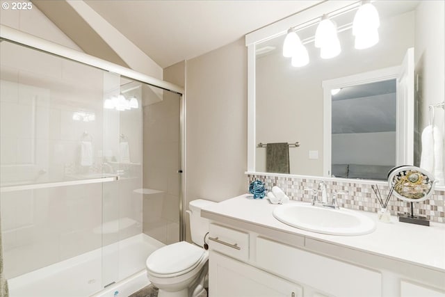 bathroom featuring decorative backsplash, a stall shower, toilet, and vanity