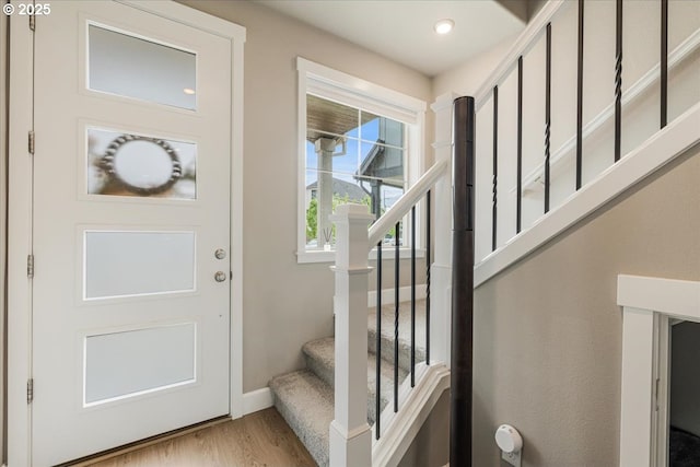 foyer with wood finished floors, stairs, and baseboards