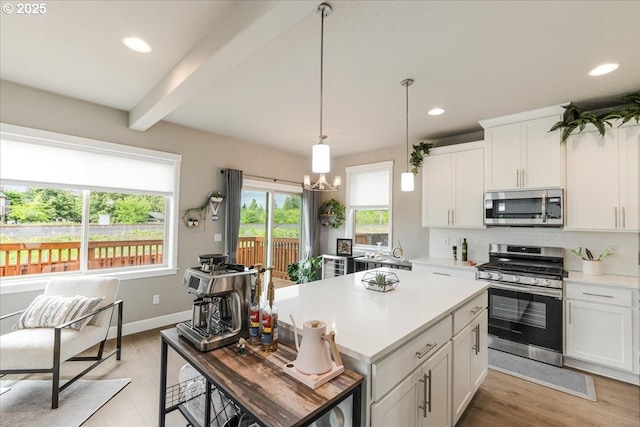 kitchen featuring appliances with stainless steel finishes, beam ceiling, light countertops, white cabinetry, and recessed lighting