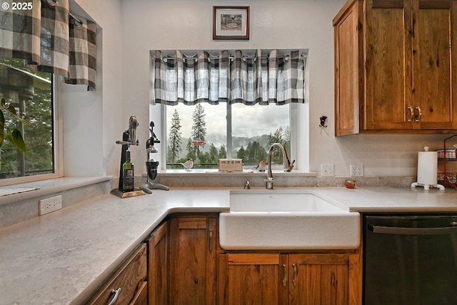 kitchen featuring light countertops, dishwasher, brown cabinetry, and a sink