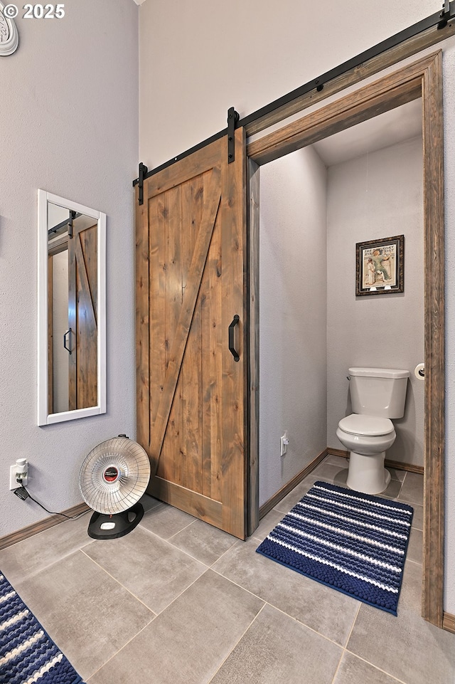 bathroom with tile patterned floors, baseboards, and toilet
