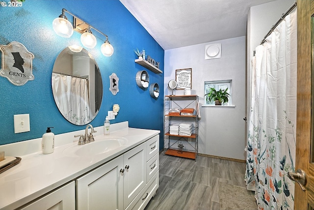 bathroom featuring vanity, wood-type flooring, and a textured ceiling