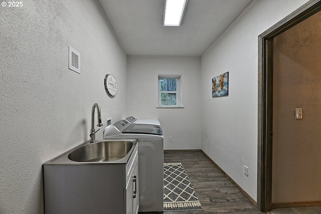 washroom featuring washing machine and dryer, sink, cabinets, and dark hardwood / wood-style flooring