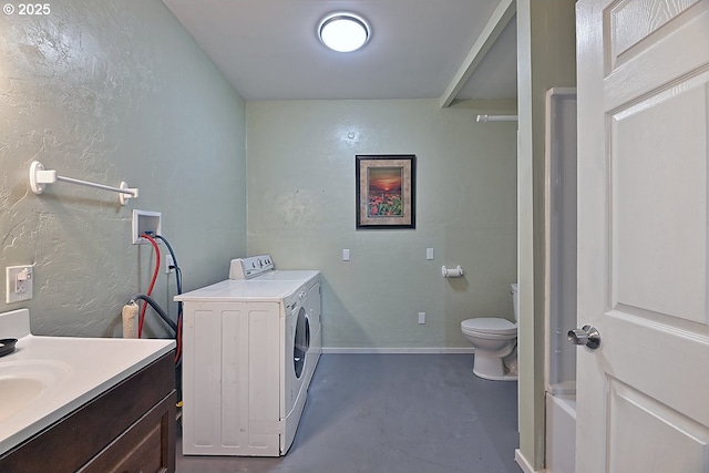 washroom featuring a textured wall, washer and clothes dryer, and laundry area