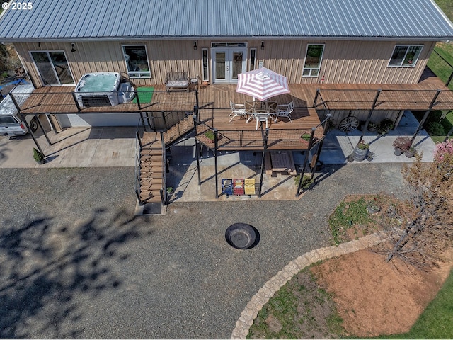 rear view of house with outdoor dining space, a wooden deck, french doors, a patio, and metal roof