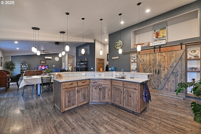 kitchen with dark wood-type flooring, light countertops, open floor plan, and a barn door