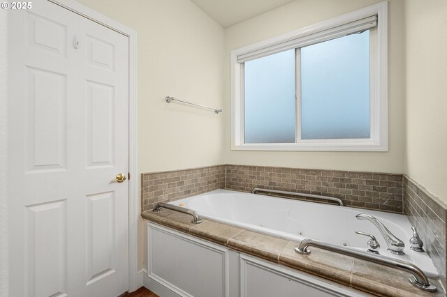 bathroom featuring plenty of natural light and tiled bath