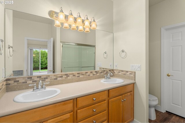 bathroom with tasteful backsplash, vanity, toilet, and walk in shower