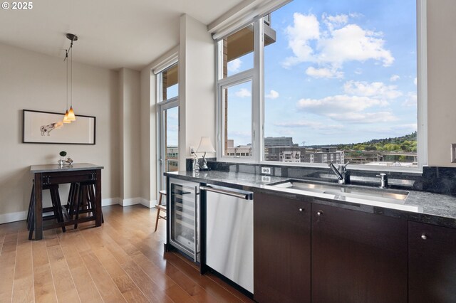 1930 S River Dr Unit W1003, Portland, OR 97201 - kitchen with wine cooler, a sink, wood finished floors, decorative light fixtures, and baseboards