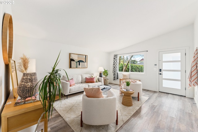 living area with lofted ceiling and light wood-style floors
