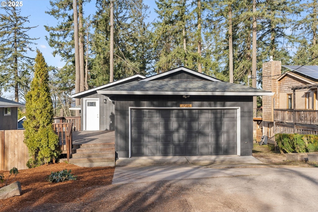 ranch-style house with a wooden deck and a garage